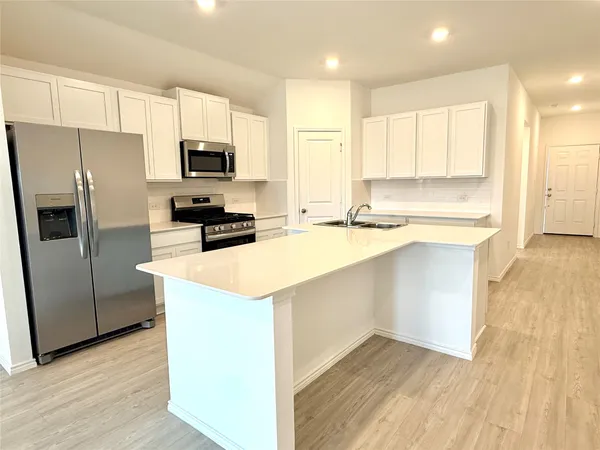 an empty room with wooden floor and cabinet