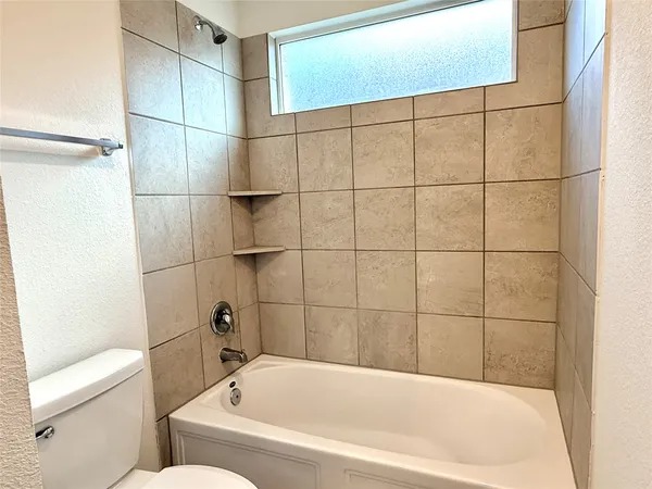 an empty room with windows and bathroom view