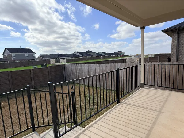 a view of a balcony with wooden floor and fence