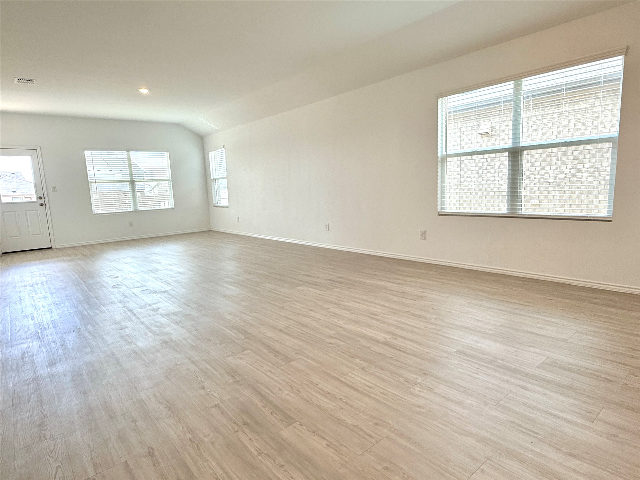 289 Sormonne Loop Kyle, TX 78640 - Photo 24 of 32 Empty room featuring light wood finished floors and vaulted ceiling