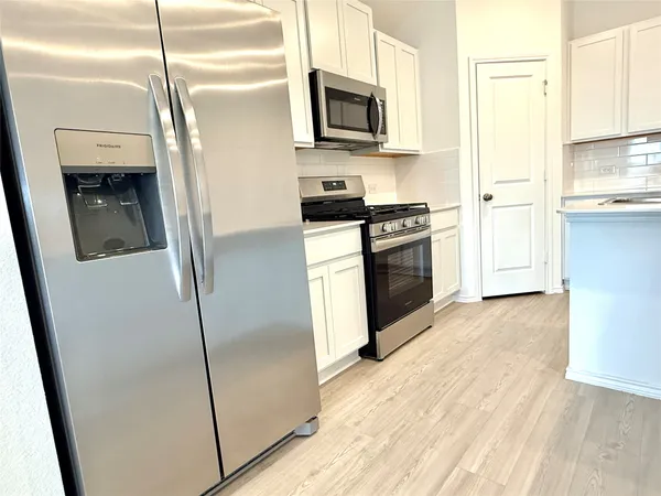 a kitchen with stainless steel appliances a refrigerator a stove a microwave and cabinets