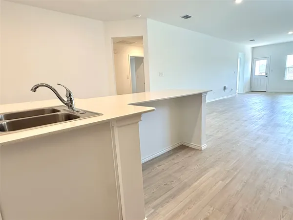 a view of a kitchen with a sink and a wooden floor