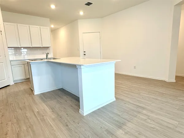a kitchen with wooden floors and cabinets