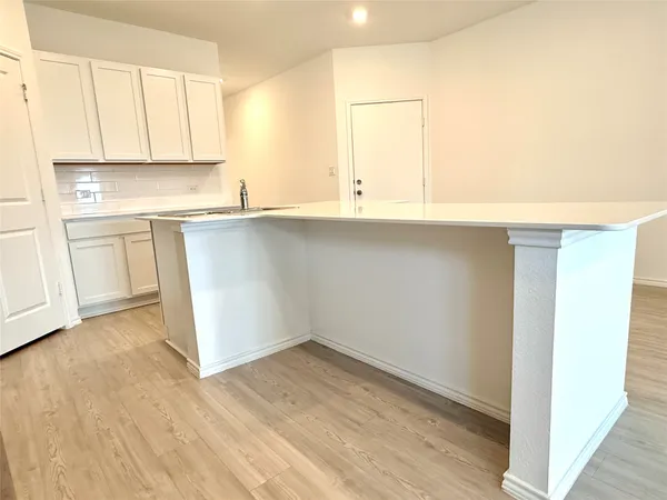 a kitchen with stainless steel appliances granite countertop a stove top oven a sink dishwasher and a refrigerator with wooden floor