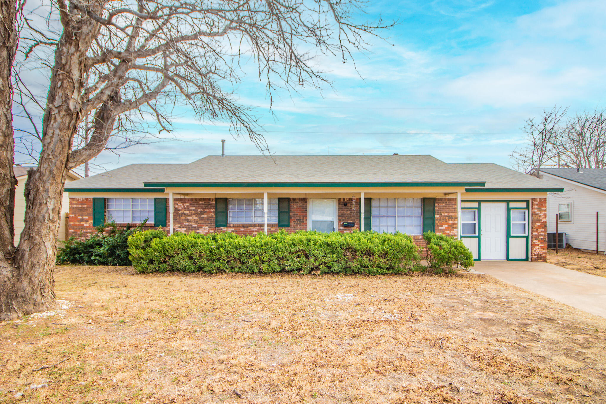 1903 71st Street Lubbock, TX 79412 - Photo 1 of 23 a view of a brick house next to a yard with potted plants