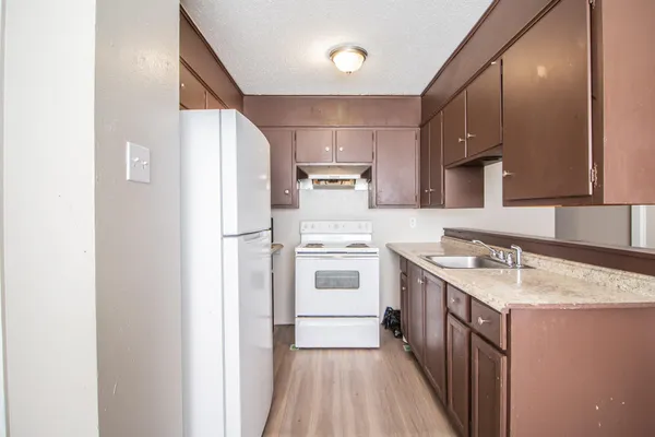 a kitchen with a sink stove and refrigerator