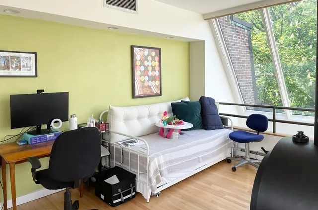 a bedroom with a bed and large windows