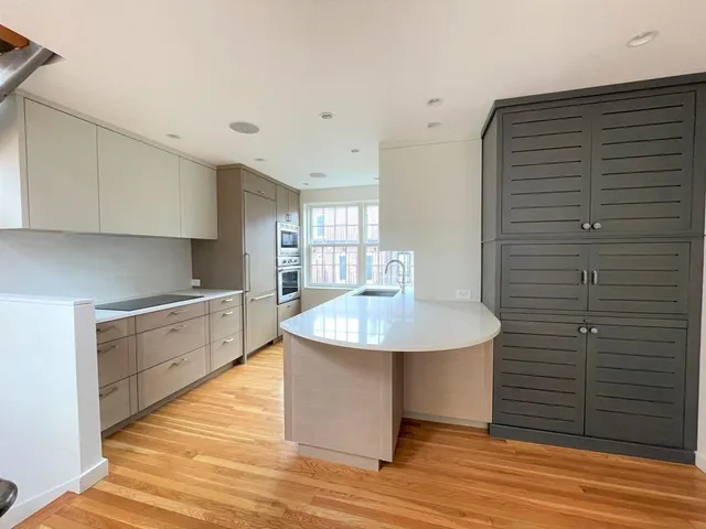 a kitchen with stainless steel appliances granite countertop a sink and white cabinets