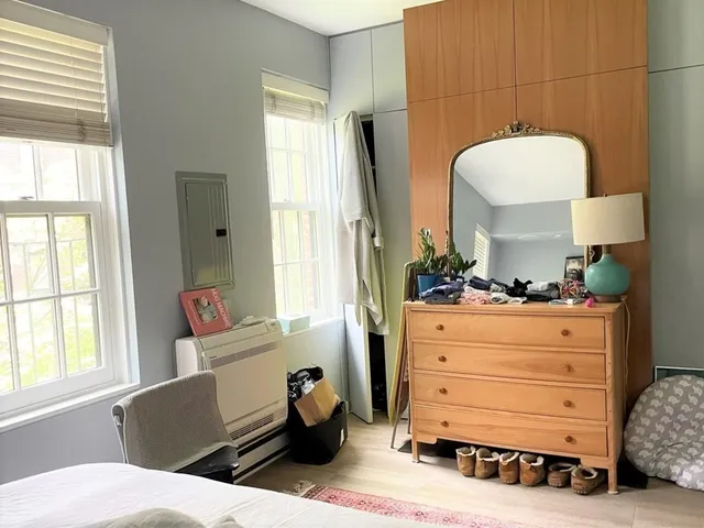 a view of an empty room with a window and fire place