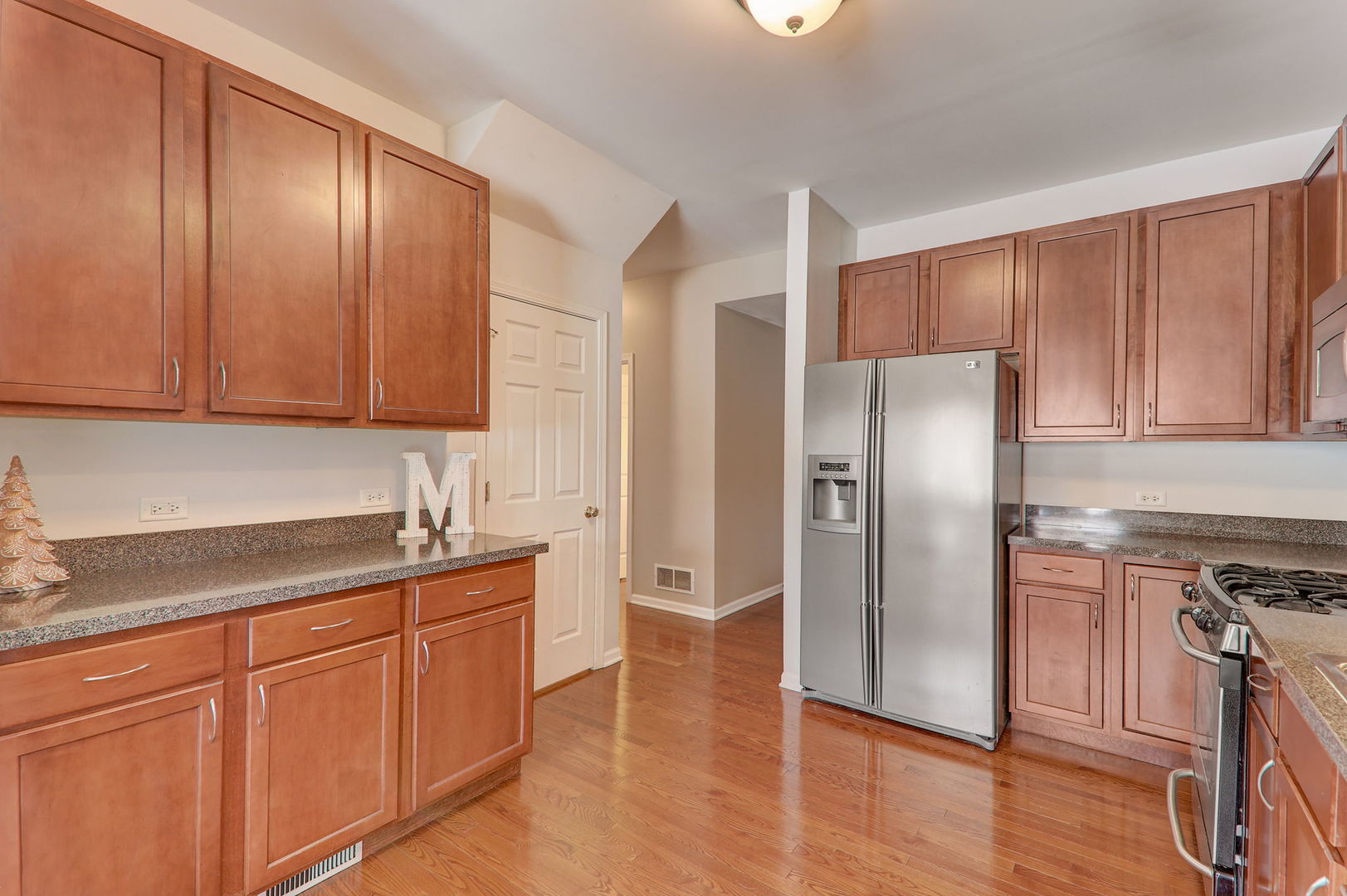 980 Oak Ridge Boulevard Elgin, IL 60120 - Photo 17 of 42 a kitchen with stainless steel appliances granite countertop a refrigerator a stove and a sink with wooden cabinets