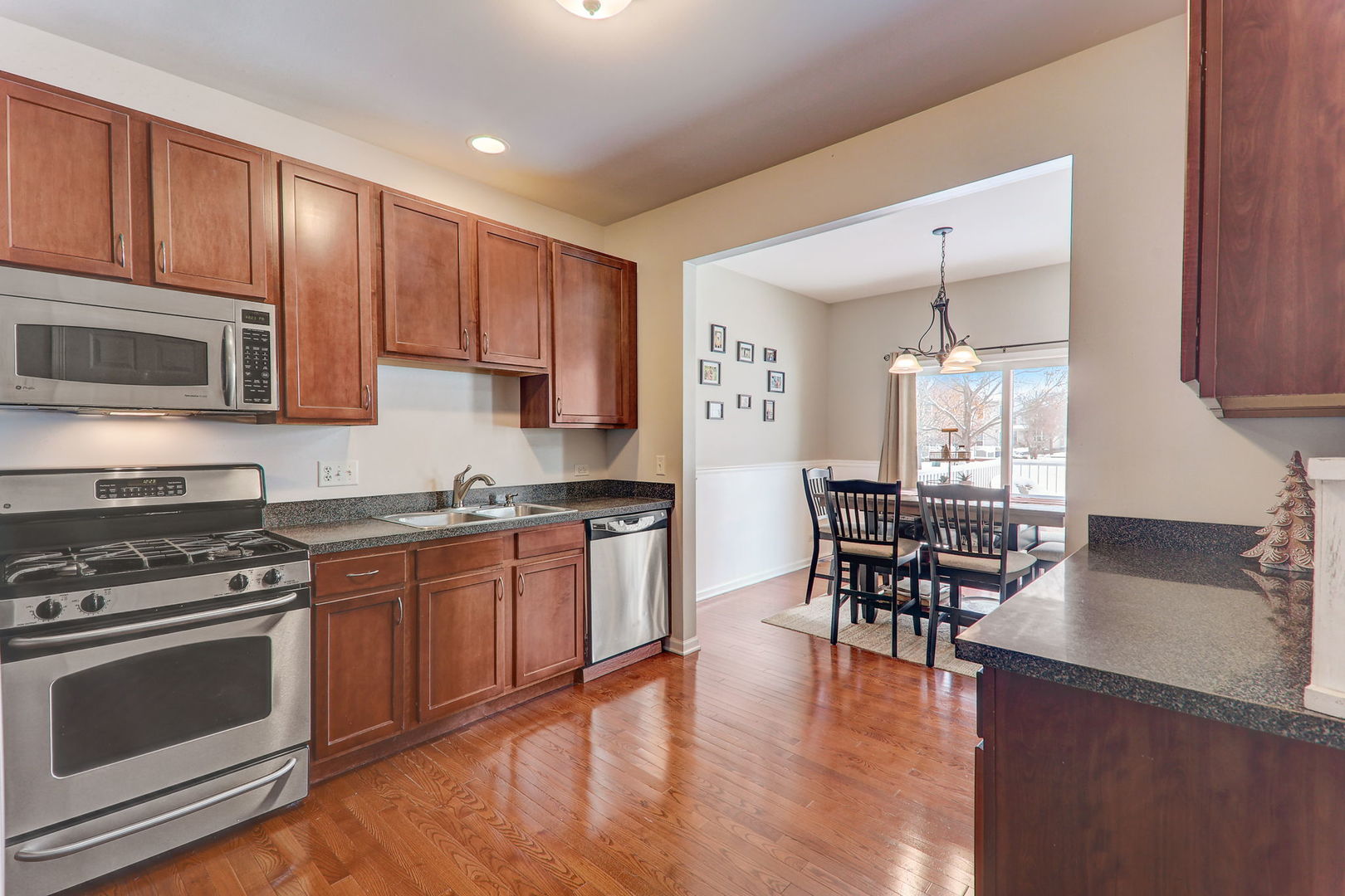 980 Oak Ridge Boulevard Elgin, IL 60120 - Photo 18 of 42 a kitchen with stainless steel appliances a stove a sink cabinets and a dining table