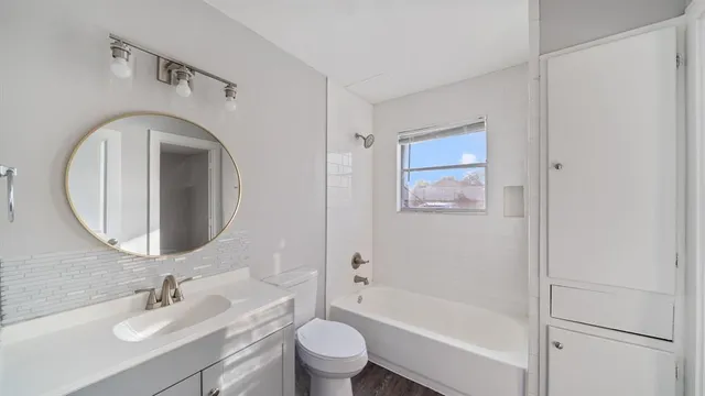 a bathroom with a toilet sink and mirror