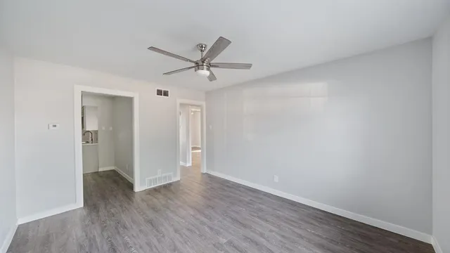 a view of a big room with wooden floor and windows in a room