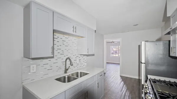 a kitchen with stainless steel appliances a sink stove and refrigerator