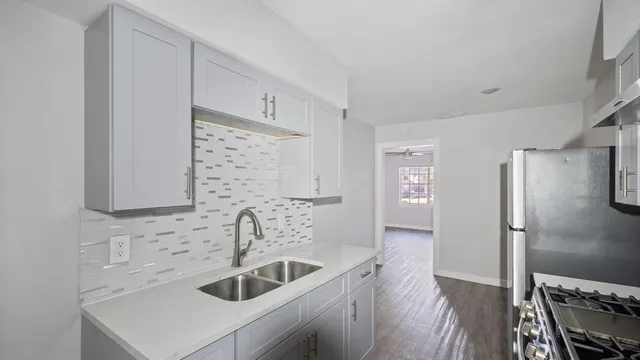 a kitchen with stainless steel appliances a sink stove and refrigerator