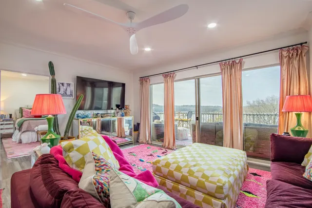a bedroom with a bed flat screen tv and a large window