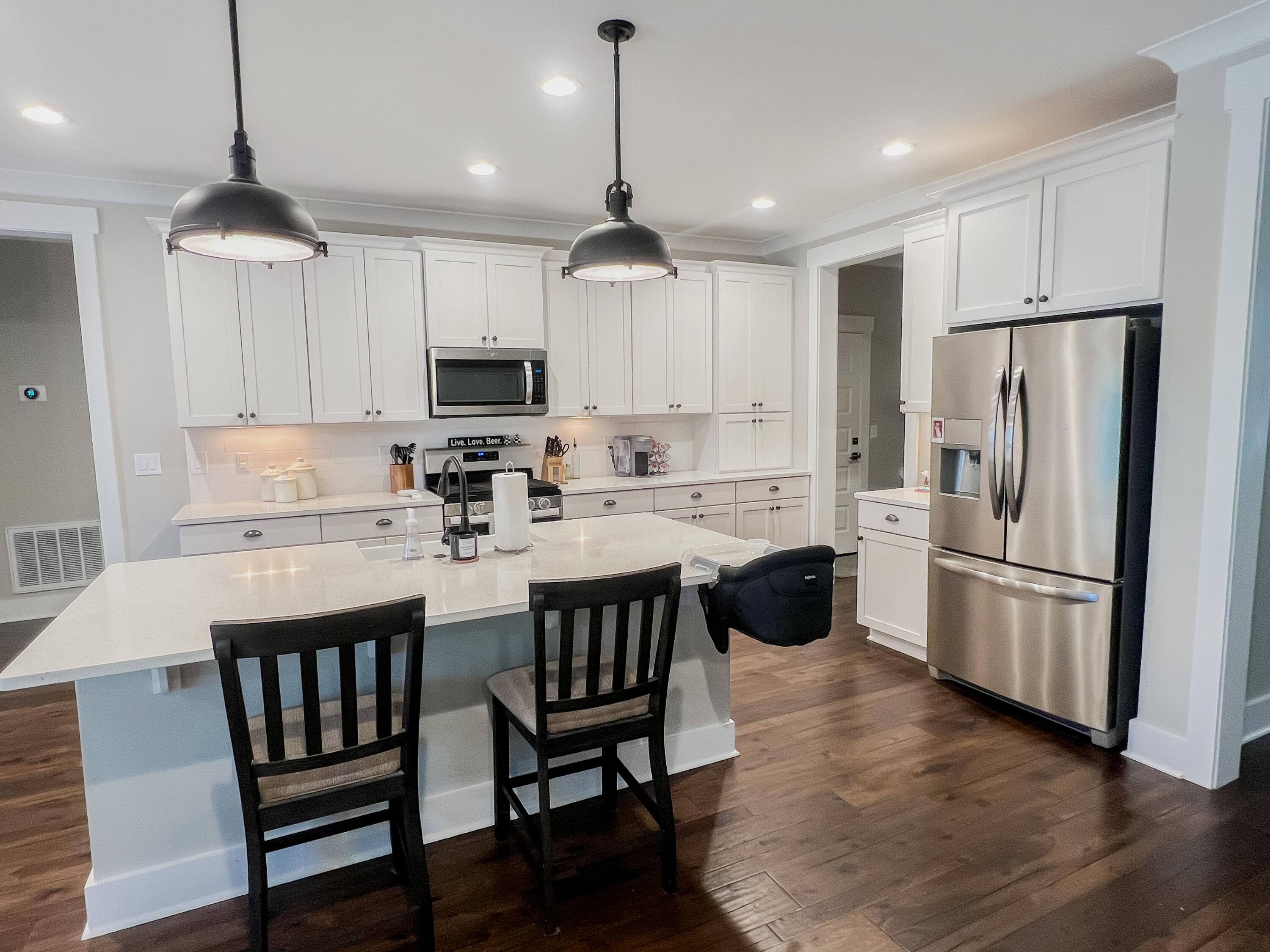 1159 Deer Moss Loop Niceville, FL 32578 - Photo 8 of 24 a kitchen with stainless steel appliances granite countertop a dining table chairs refrigerator and microwave