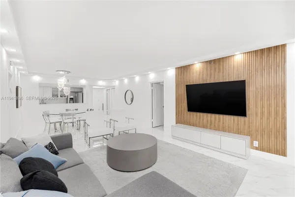 a living room with furniture a large window and a view of kitchen