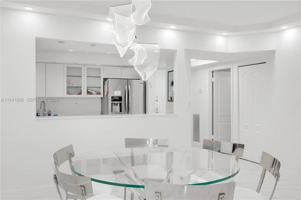 a dining room with wooden floor a glass table and chairs