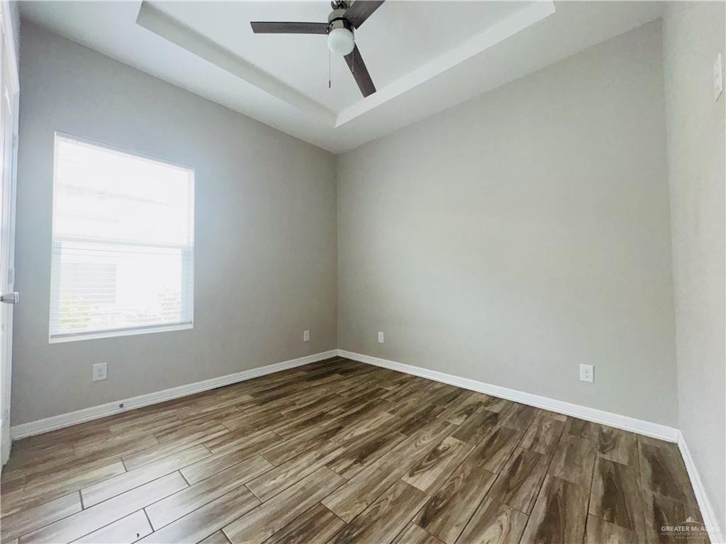 812 Kentucky Street, Unit 1 Mission, TX 78573 - Photo 12 of 18 an empty room with wooden floor and windows
