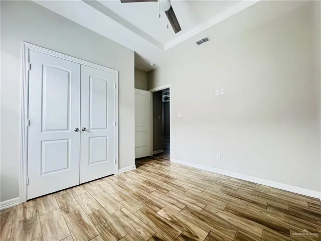 a view of an empty room with wooden floor