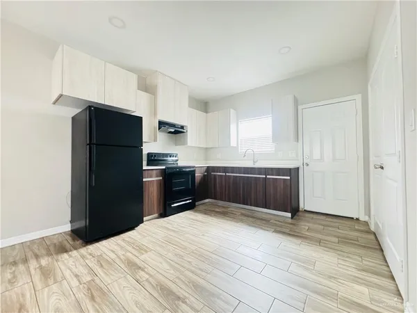 a kitchen with granite countertop a refrigerator and a sink