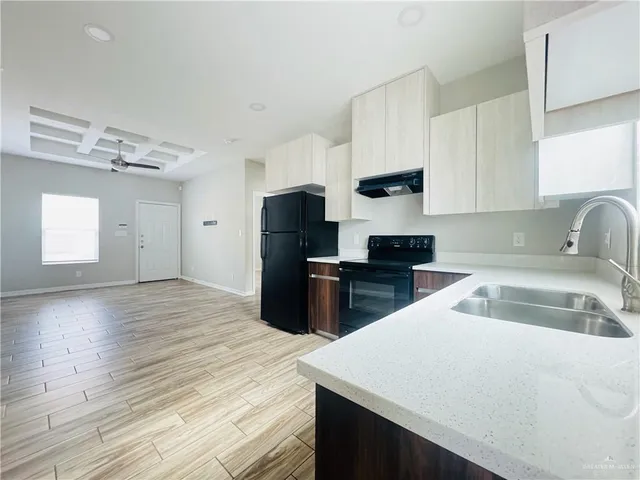 a kitchen with granite countertop a refrigerator sink and stove