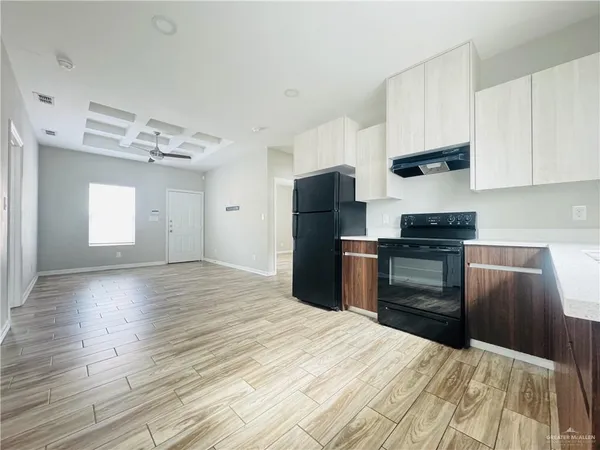 a kitchen with granite countertop a refrigerator stove top oven and sink