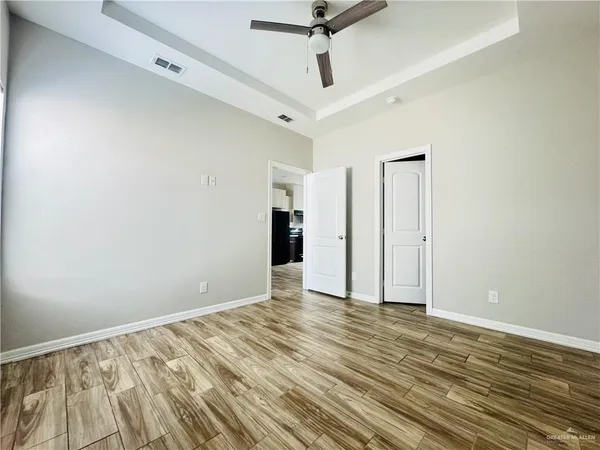a view of an empty room with wooden floor