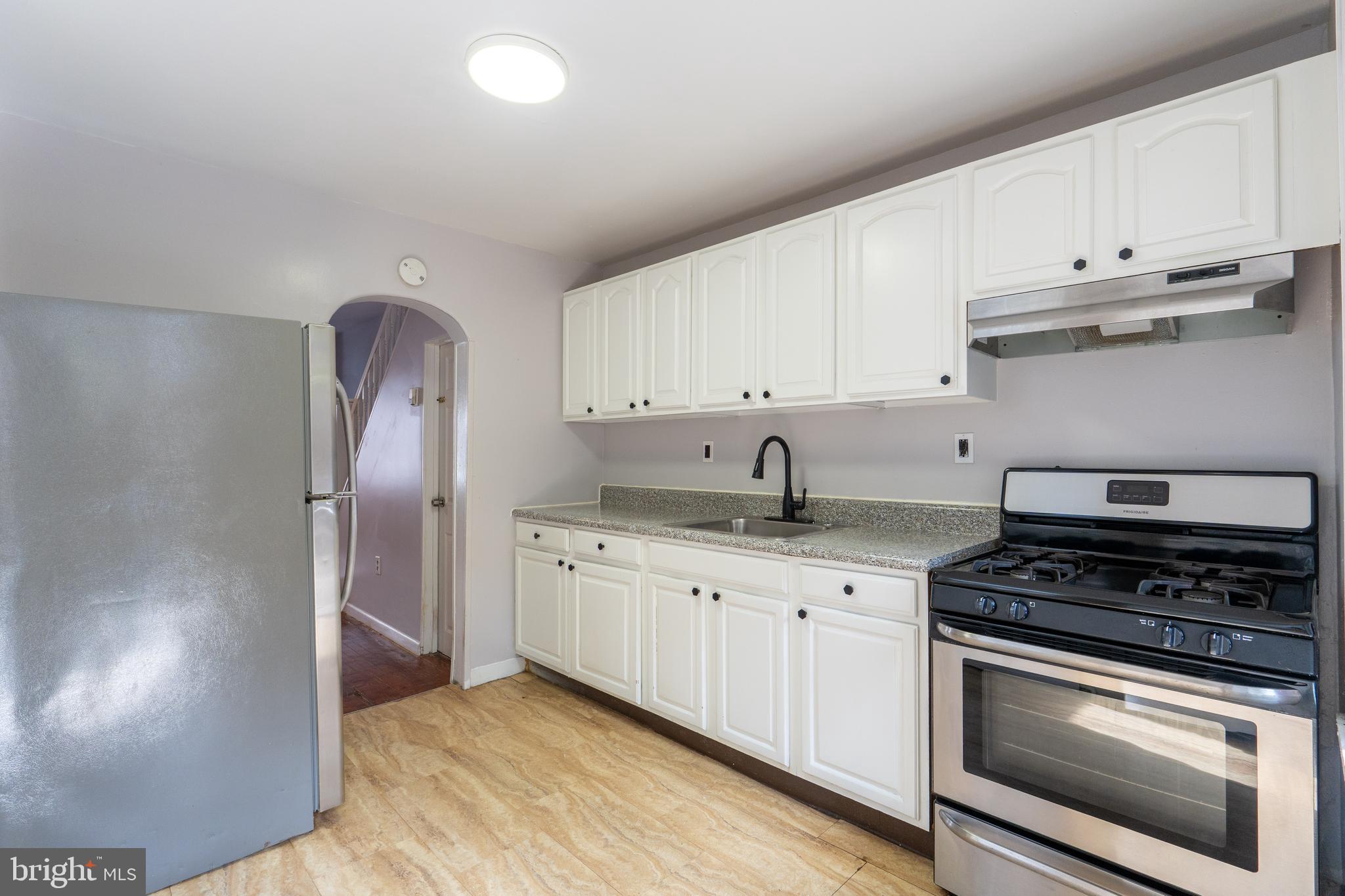 1826 McClellan Street Philadelphia, PA 19145 - Photo 7 of 22 a kitchen with stainless steel appliances granite countertop a stove a sink and a refrigerator