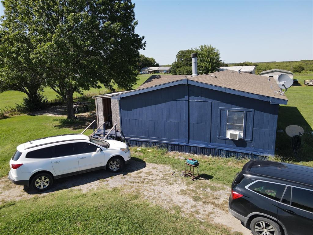 16531 Farm To Market 455 Pilot Point, TX 76258 - Photo 37 of 37 View of side of home featuring a lawn and an outdoor structure
