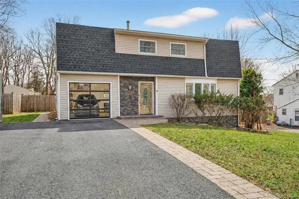 a front view of a house with a yard and garage