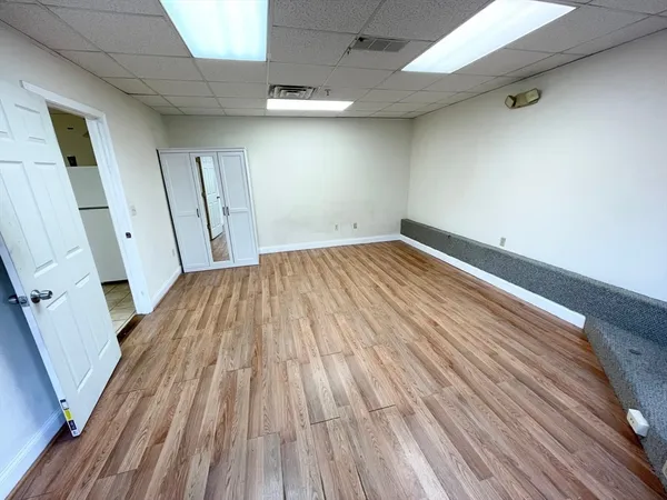 an empty room with wooden floor and entrance