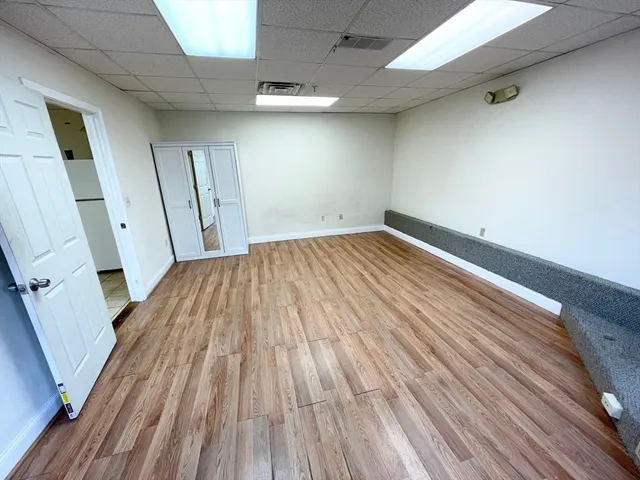 an empty room with wooden floor and entrance