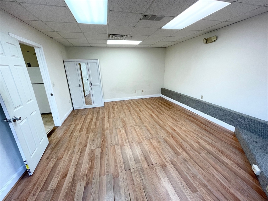 12 Pratt Street, Unit 105A Mansfield, MA 02048 - Photo 6 of 20 an empty room with wooden floor and entrance