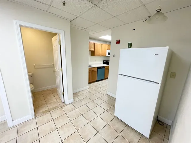 a kitchen with a refrigerator sink and cabinets