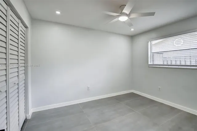 an empty room with a window and a fan