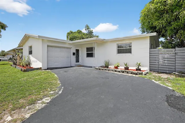 a view of a house with backyard and a garage
