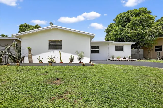 a view of a backyard with plants and a patio