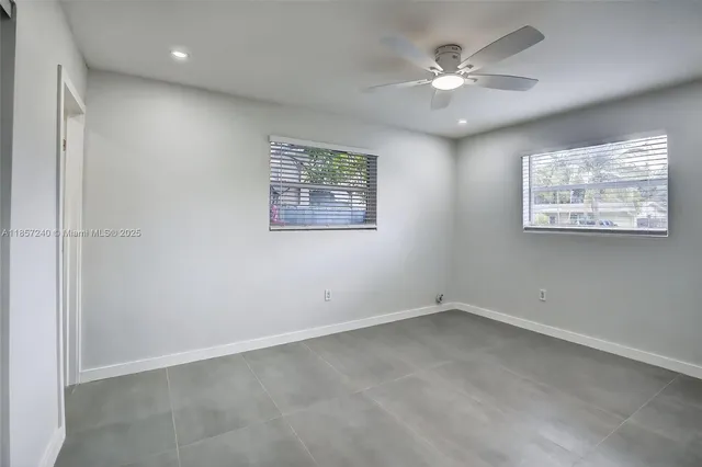 an empty room with windows and fan