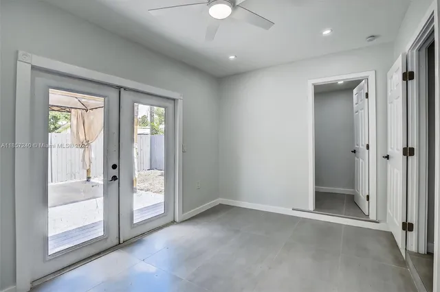 an empty room with sliding door and a chandelier fan