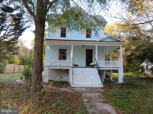 a view of a house with a tree in front of it
