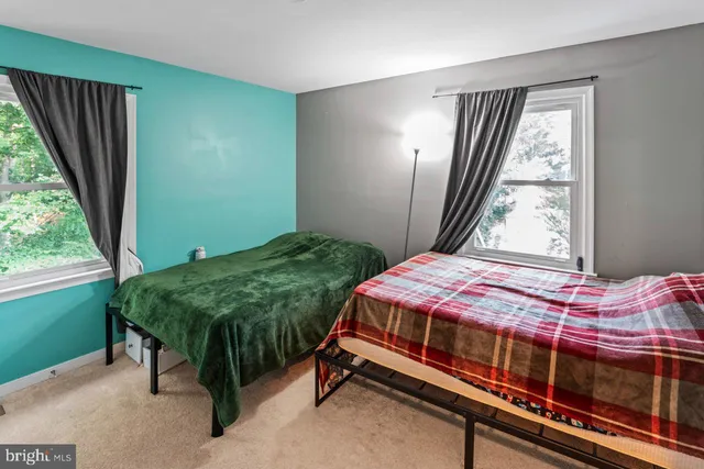 a bed sitting in a bedroom next to a window