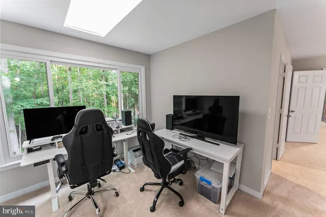 a view of a workspace with furniture and a window