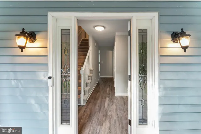 a view of hallway with wooden floor and stairs