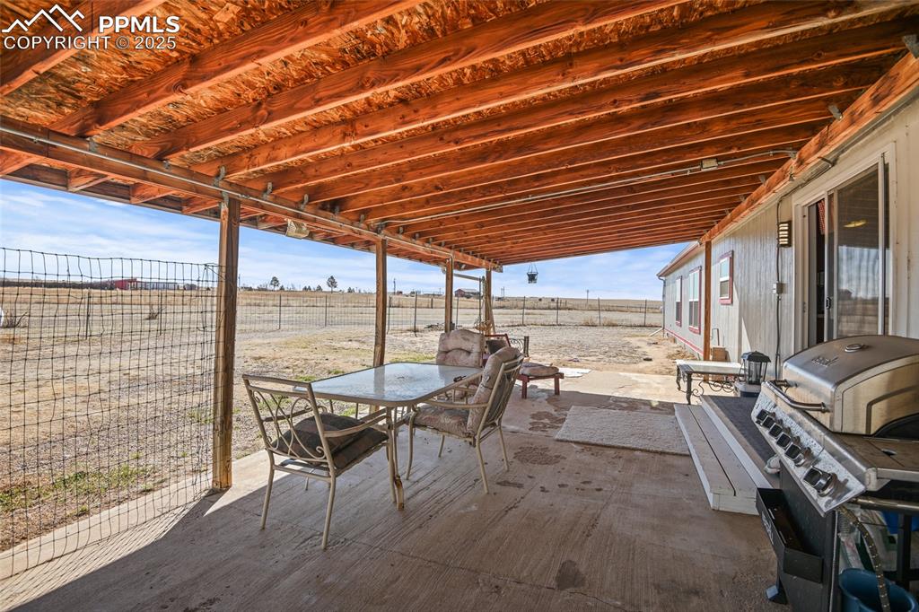 33440 Highway 94 Yoder, CO 80864 - Photo 24 of 30 a view of a patio with a dining table and chairs with wooden floor