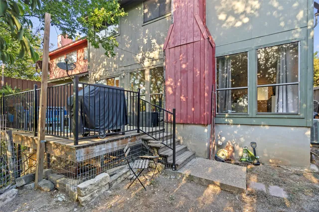 a view of a backyard with wooden fence and a large tree