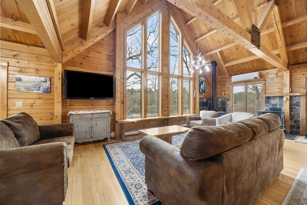 119 Valley Bars Road Bourne, MA 02532 - Photo 6 of 36 a living room with furniture a flat screen tv and a floor to ceiling window