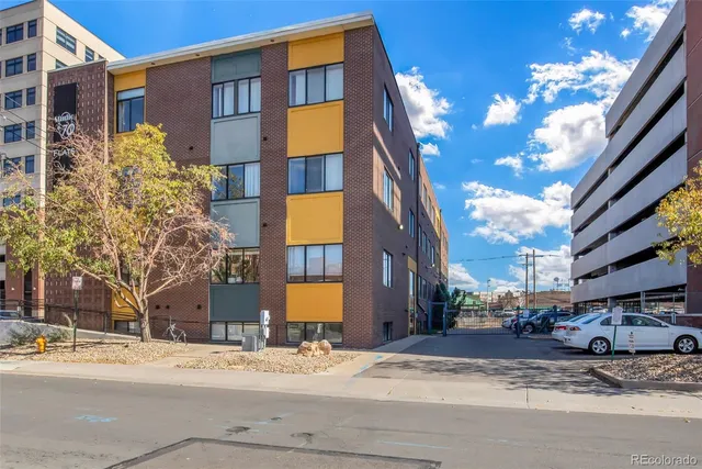 a front view of a building with a street light pole and trees