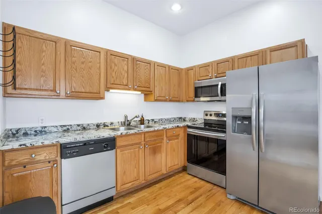 a kitchen with stainless steel appliances granite countertop a refrigerator sink and cabinets